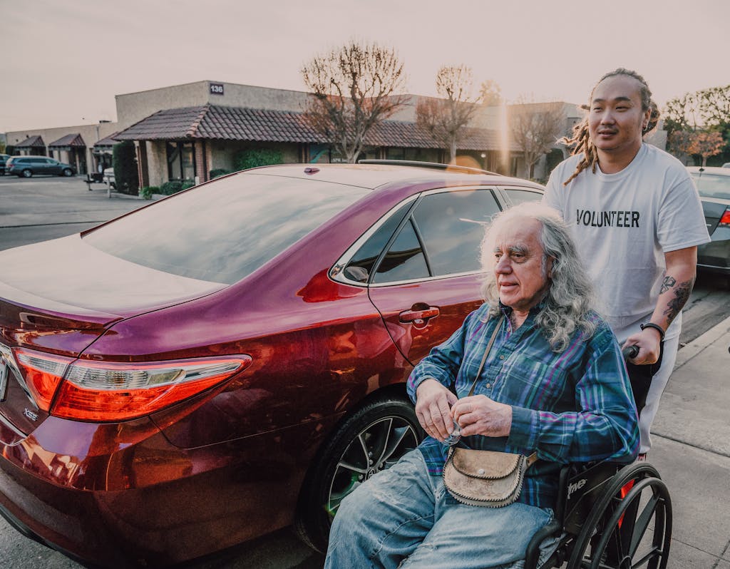 A Man Pushing a Wheelchair on the Street